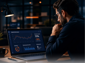 Man wearing glasses sits at a dimly lit desk at night, looking at a laptop displaying a financial dashboard with stock charts, percentages (73% gain, -18%) and bar graphs.